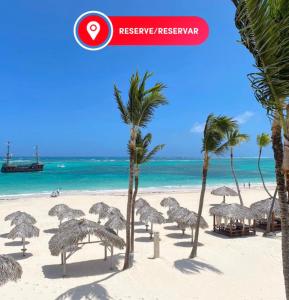 a group of palm trees on a beach with the ocean at TROPICAL ADVENTURE Sol Caribe STUDIOS SUITES Beach CLUB & SPA in Punta Cana