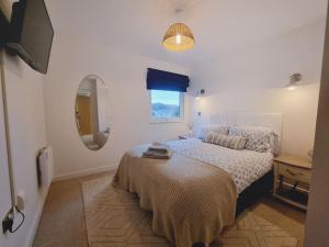 a bedroom with a bed and a mirror and a window at Riverview Apartment in Cardiff