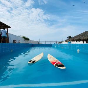 dos tablas de surf en el agua en una piscina en Zorritos Backpakers, en Tumbes