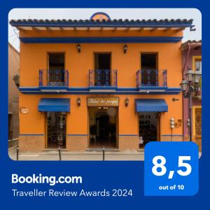 un bâtiment jaune avec des balcons bleus dans une rue dans l'établissement Hotel del Parque Naolinco, à Naolinco