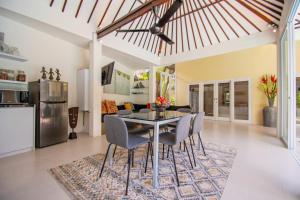 a dining room and living room with a table and chairs at Sitara Villa in Seminyak