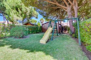Un parque infantil con un tobogán en un patio en AL - Moradia Vila Brasil, en Vilamoura