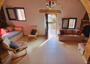 a living room with a couch and a chair at Yiannis Village house in Asklipiḯon