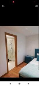 sypialnia z łóżkiem i drzwiami z lustrem w obiekcie Moradias dos Castelos (Azul ) w mieście Ourém