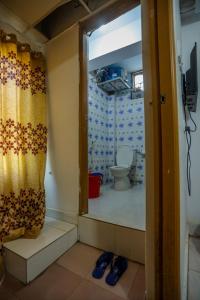 a bathroom with a toilet and a shower curtain at Hotel City International Green Road in Dhaka