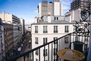 - un balcon offrant une vue sur un bâtiment blanc dans l'établissement Hôtel de Charonne, à Paris