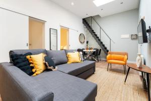 a living room with a gray couch and an orange chair at Enamorats in Barcelona