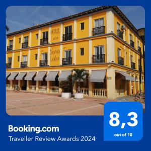 a yellow building with white awnings on it at Hotel Posada Doña Lala in Tlacotalpan