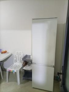 einen Kühlschrank in einer Küche mit einem Tisch und einem Stuhl in der Unterkunft La petite Kasbah in Marrakesch