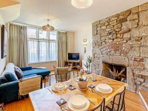 a living room with a table and a stone fireplace at 1 Bed in Gulval 88293 in Gulval