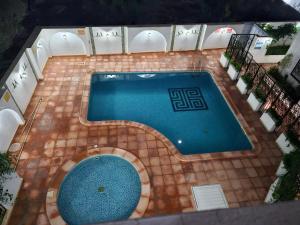 - une vue sur la piscine située dans un bâtiment dans l'établissement Villa Jasmin Super equipped apartment with Garden, Swimming pool, Sea, à Hammamet