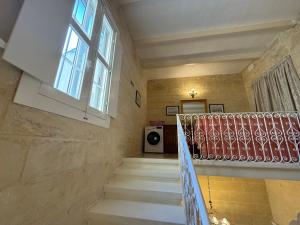 - un escalier dans une maison avec une fenêtre et une rampe d'escalier dans l'établissement B&S Accommodation 1940 House of Character, à Żejtun