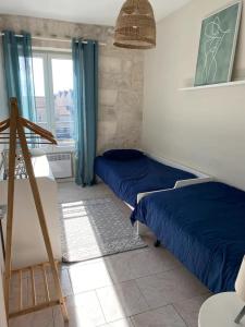 1 dormitorio con 2 camas y ventana en Appartement Belle-vue, en Beaucaire