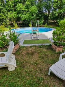 een tuin met 2 stoelen en een zwembad bij Demeure de 7 chambres avec piscine privee terrasse et wifi a Mosnay in Mosnay