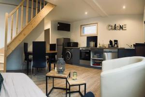 a living room with a couch and a kitchen at le relais du chatô in Quend