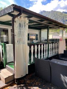 a gazebo sitting on a porch with a fence at Mobile Home Italy in Porlezza