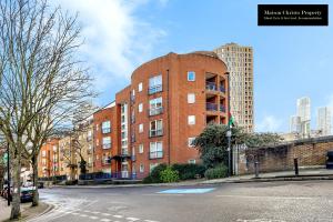 a red brick building on the side of a street at Caraway Heights 2Bedroom Apt Sleeps 6 in Canary Wharf, London with Free Parking, Wifi & Leisure By Maison Christo Property Short Lets & Serviced Accommodation in London