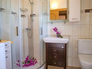 uma casa de banho com um chuveiro e um lavatório com flores roxas em Villa Lindos Star in Rodos with Private pool em Kalathos