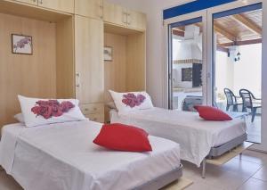 a room with two beds with red pillows on them at Villa Lindos Star in Rodos with Private pool in Kalathos
