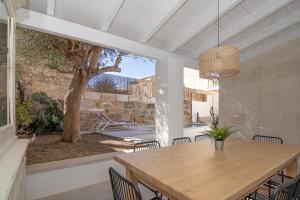 ein Esszimmer mit einem Tisch, Stühlen und einem Baum in der Unterkunft Son Moro 269 by Mallorca Charme in Muro