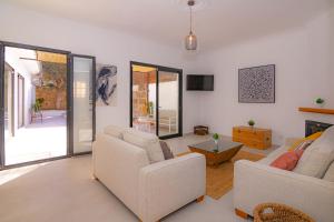 ein Wohnzimmer mit 2 weißen Sofas und einem TV in der Unterkunft Son Moro 269 by Mallorca Charme in Muro