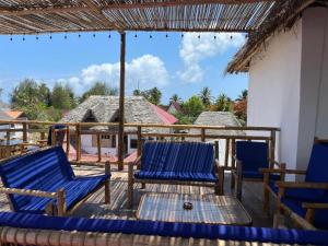 una terrazza con sedie blu e ombrellone di Babalao Villa a Paje