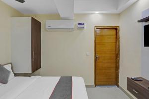 - une chambre avec un lit et une porte en bois dans l'établissement Meera Eternity, à Noida