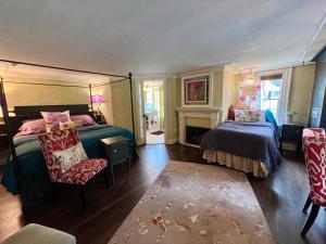 1 dormitorio con 2 camas y chimenea en The Connecticut River Valley Inn Hartford South/Glastonbury, en Glastonbury