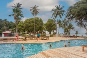 une femme debout dans une piscine d'un complexe dans l'établissement Langley Resort Fort Royal, à Deshaies