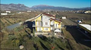 a house in a field with mountains in the background at Hotel Villa Linda in Shkodër