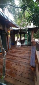 eine Holzterrasse mit Bäumen und ein Gebäude in der Unterkunft Casa das Orquídeas in Bonito