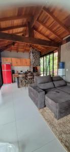 ein Wohnzimmer mit einem Sofa und einem Tisch in der Unterkunft Casa das Orquídeas in Bonito