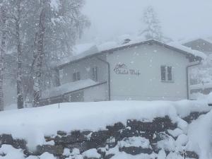 un edificio cubierto de nieve con un cartel. en Chalet Weiß en Mönichkirchen