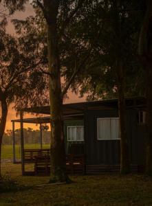 a cabin with a picnic table and a tree at Cabañas El Calabres in Tacuarembó