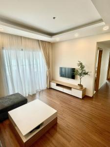 ein Wohnzimmer mit einem Sofa und einem TV in der Unterkunft CĂN HỘ CAO CẤP FLC SEATOWN QUY NHƠN in Quy Nhon