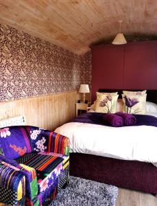 - une chambre avec un lit et une chaise dans l'établissement Shepherd's Hut at Cefn Tilla Court, à Usk