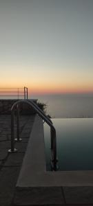 a pool with a metal railing next to the water at Point of View Andromeda in Drymon