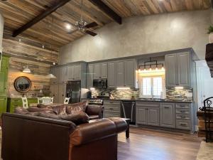 a living room with a leather couch in a kitchen at Elegant Country Cottage in Caldwell Crossing