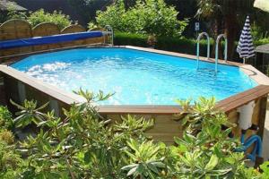 uma grande piscina num quintal com árvores em Maison dans un mas le Moulin Piot em Bellegarde