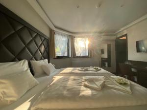 a bedroom with a large white bed with towels on it at Hotel Lotus in Hermina-major