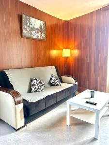 ein Wohnzimmer mit einem Sofa und einem Tisch in der Unterkunft Au bord de la Furieuse, proche de la Grande Saline et des Thermes de Salins-les-Bains in Salins-les-Bains
