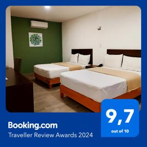 Noas Hotel في Matamoros: سريرين في غرفة فندق بجدران خضراء