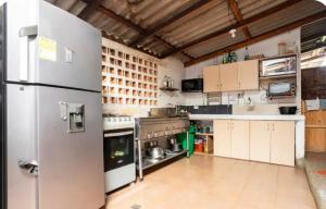 a large kitchen with white cabinets and a refrigerator at Picnic el Altico in Caldas