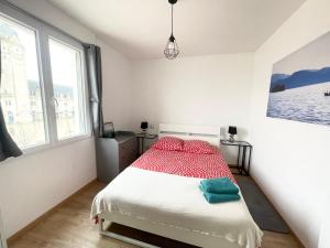 ラ・ロシェルにあるAppartement La Guignetteのベッドルーム1室(赤と緑の枕が備わるベッド1台付)