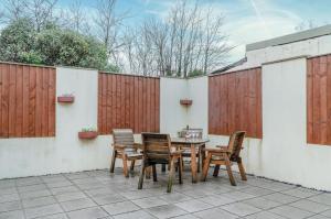 a table and chairs on a patio with a fence at The Brambles - 2 bedroom Cottage - Llanteg in Pembrokeshire