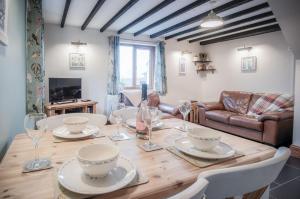 a dining room with a wooden table with wine glasses at The Brambles - 2 bedroom Cottage - Llanteg in Pembrokeshire