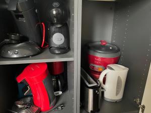 einen Schrank mit einer Kaffeemaschine und einer Kaffeemaschine in der Unterkunft Appartement La Guignette in La Rochelle