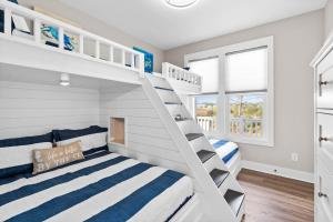 a bedroom with two bunk beds and a staircase at Coastal Charm Ocean Isle Beach custom beach home with 4 bedroom, 3 bath home with pool and elevator in Ocean Isle Beach +45 photos