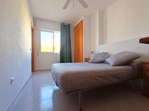 um quarto com uma cama com almofadas e uma janela em AyF 3 HABITACIONES EN PLAYA MORRO DE GOS em Oropesa del Mar