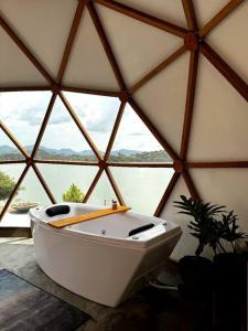 a white bath tub in a room with a window at Lunar HOME (Casa Bolha) Pé na água in Joanópolis